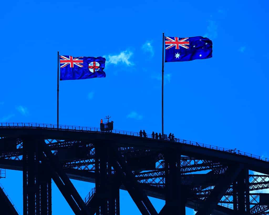 blue red and yellow flag on black metal bridge under blue sky during daytime